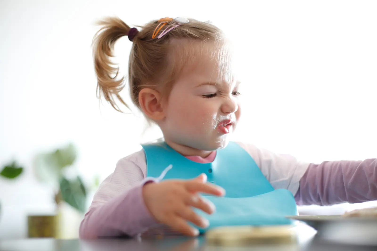 Unhappy kid with yogurt on her face